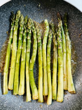 Yeşil kuşkonmaz kabukları kızartma tavasında yağda kızartılır. Yüksek kalite fotoğraf