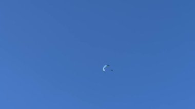 Parasailer mavi gökyüzünde paraşütle süzülüyor. Yüksek kalite 4k görüntü