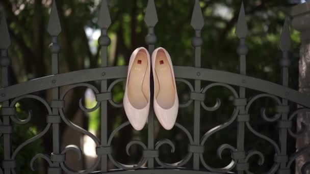 Παπούτσια Της Νύφης Κρέμονται Στον Μεταλλικό Φράχτη Του Κήπου Τίτλος — Αρχείο Βίντεο