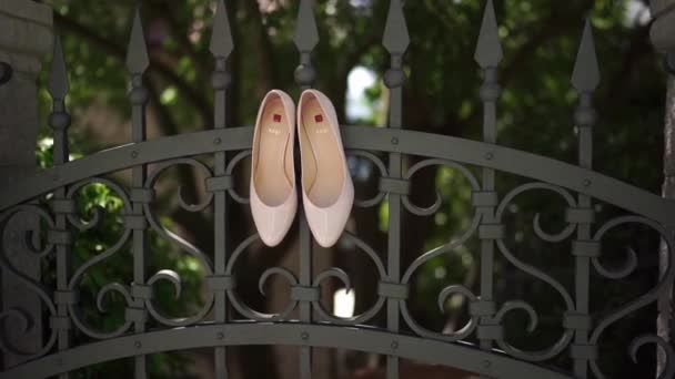 Νυφικά Παπούτσια Κρέμονται Στον Σιδερένιο Φράχτη Του Κήπου Κοντινό Πλάνο — Αρχείο Βίντεο