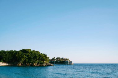 Kotor Körfezi 'ndeki Sveti Stefan adası yeşil pelerinin arkasında görünür. Karadağ. Yüksek kalite fotoğraf