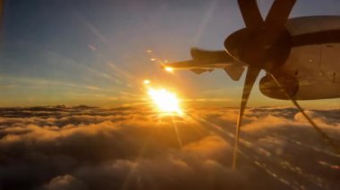 Batan güneşin parlak ışınlarıyla bulutların üzerinde uçan bir uçağın pervanesi. Yüksek kalite 4k görüntü