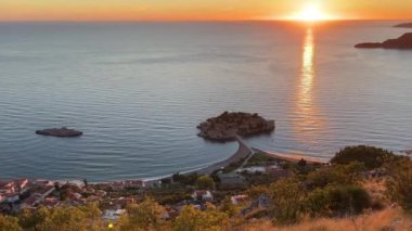 Sveti Stefan adası günbatımı gökyüzünün arka planına karşı. Karadağ. Yüksek kalite 4k görüntü