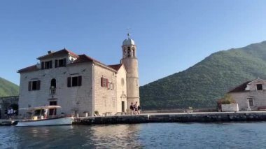 Turistler Gospa od Skrpjela adasında kilisenin yakınında dolaşıyorlar. Kotor Körfezi, Karadağ. Yüksek kalite 4k görüntü