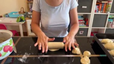 Kadın masaya küçük bir oklavayla bir parça hamur atıyor. Yüksek kalite 4k görüntü