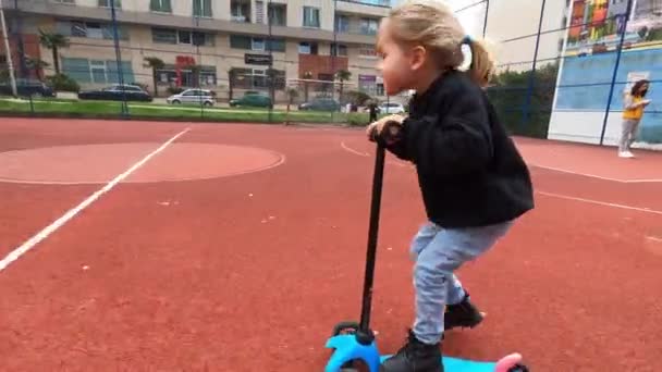 Little Girl Rides Scooter Football Field Yard High Quality Footage Video Clip
