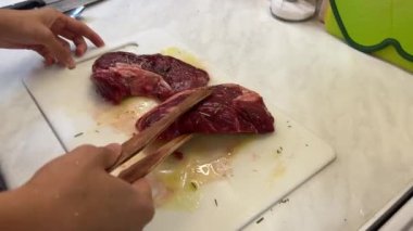 Ev hanımı, biberiyeli et parçalarını maşayla ızgaraya koyar. Yüksek kalite 4k görüntü
