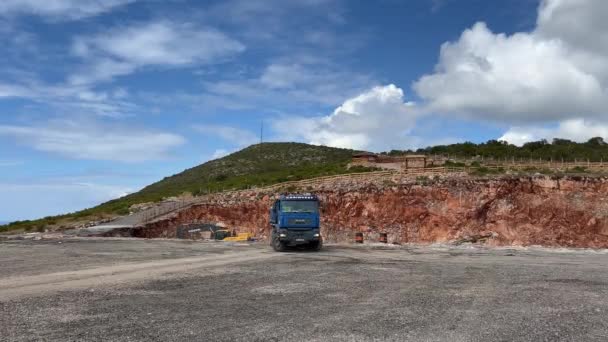 卡车穿过采石场 向一辆黄色挖掘机驶去 高质量的4K镜头 — 图库视频影像