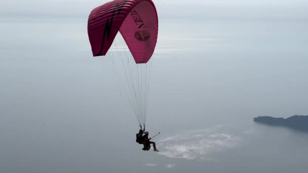 跳伞者们正乘坐降落伞飞越海滨的山脉 高质量的4K镜头 — 图库视频影像