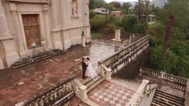 Gelin ve damat Meryem 'in Doğuşu Kilisesi' nin önünde kucaklaşıyor. Prcanj. Yüksek kalite 4k görüntü