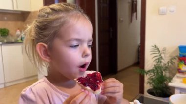 Küçük kız mutfakta reçelli çörek yiyor. Yüksek kalite 4k görüntü