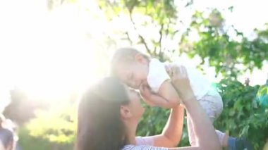 Anne bebeği kollarıyla kaldırıyor ve burnuyla burnuna dokunuyor. Yüksek kalite 4k görüntü