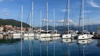 Yelkenli yatlar, dağların arka planına karşı iskelede demirli. Yüksek kalite 4k görüntü