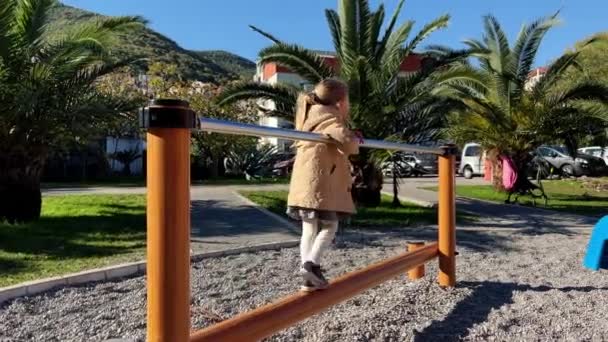 Küçük Kız Çocuk Parkında Tırabzana Tutunarak Kirişin Üzerinde Yürüyor Yüksek — Stok video