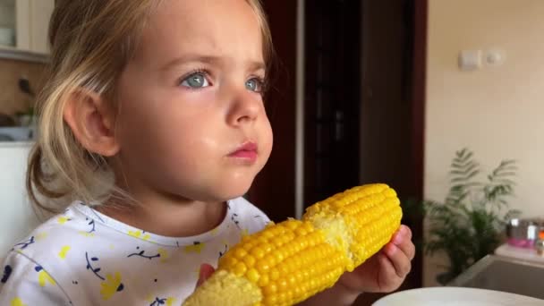 Meisje Knabbelt Een Maïskolf Aan Tafel Hoge Kwaliteit Beeldmateriaal — Stockvideo