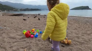 Küçük kızlar kumsalda renkli oyuncaklarla oynarlar. Yüksek kalite 4k görüntü