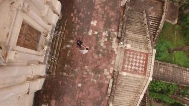 Gelin ve damat kilisenin yakınında el ele tutuşuyorlar. Drone. Yüksek kalite 4k görüntü