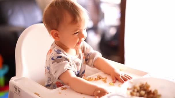 Small Child Crumbled Bun Table While Sitting High Chair Turns — Stock Video