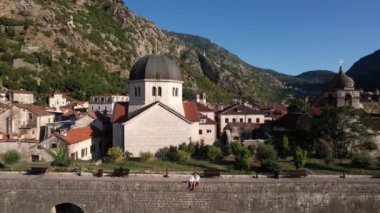 Kotor 'daki Aziz Niklas Kilisesi' nin önündeki taş köprüde oturan kadın ve erkek. Karadağ. Yüksek kalite 4k görüntü