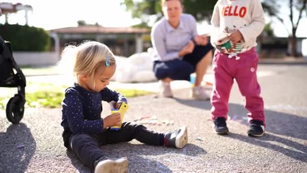 Mama Beobachtet Kleine Mädchen Die Mit Buntstiften Auf Dem Bürgersteig — Stockvideo