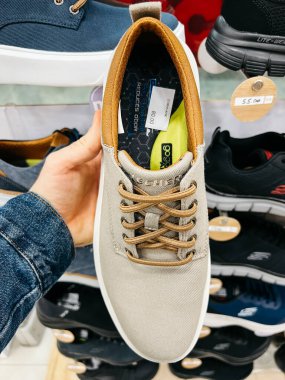 Adam bir mağazada elinde tekstil ayakkabısı tutuyor. Yüksek kalite fotoğraf