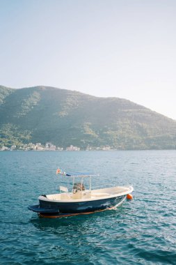 Balıkçı teknesi dağların arka planında dalgalar üzerinde sallanıyor. Yüksek kalite fotoğraf