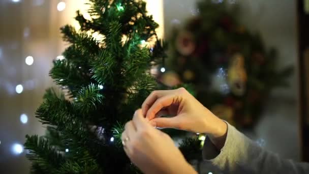 女人把金球挂在圣诞树上 高质量的4K镜头 — 图库视频影像