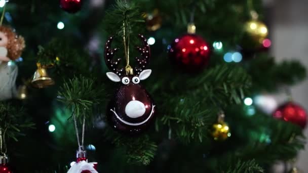 一只笑着的鹿的雕像挂在球中间一棵圣诞树的绿枝上 高质量的4K镜头 — 图库视频影像