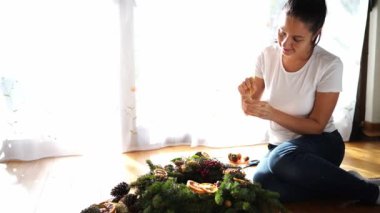 Dekoratör altın boyayla bir Noel çelengi boyuyor. Yüksek kalite 4k görüntü