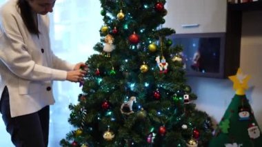 Anne ve küçük kız Noel ağacını süslüyor. Yüksek kalite 4k görüntü