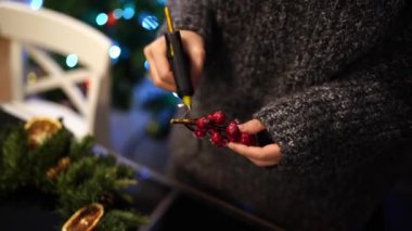 Sanatçı kuru böğürtlenli bir dala yapıştırıp yeni yıl çelengine yapıştırıyor. Yüksek kalite 4k görüntü