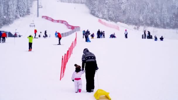 在Kolasin 1600滑雪中心 妈妈带着一个带着雪橇的小女孩爬山 高质量的4K镜头 — 图库视频影像