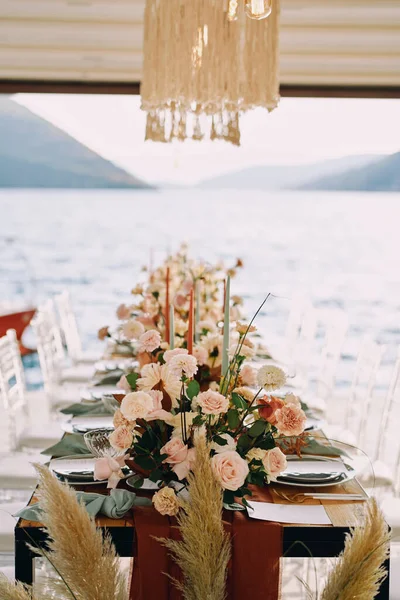 Lange Festliche Tische Mit Blumen Und Stühlen Stehen Auf Einem lizenzfreie Stockbilder