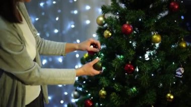 Kadın Noel ağacına parlak toplar asıyor. Yüksek kalite 4k görüntü