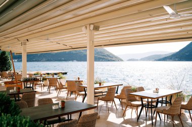 Deniz kenarındaki bir rıhtımda, dağların manzaralı bir restoranın tepesinde. Yüksek kalite fotoğraf
