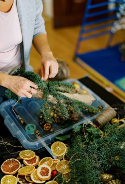 Dekoratör kozalaklı dallardan yeni yıl çelengi örüyor. Yüksek kalite fotoğraf