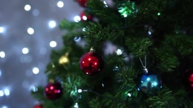 Noel ağacının yeşil dallarında çok renkli toplar asılı. Yüksek kalite 4k görüntü