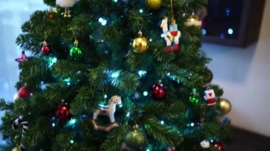 Renkli toplar, oyuncaklar ve parlak çelenklerle süslenmiş Noel ağacı bir odada duruyor. Yüksek kalite 4k görüntü