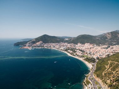 Budva kıyısındaki deniz kıyısında, dağların eteğindeki otoyol. Karadağ. Drone. Yüksek kalite fotoğraf