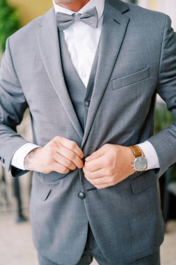 Damat ceketinin düğmelerini bağlar. Kırpılmış. Yüzsüz. Yüksek kalite fotoğraf