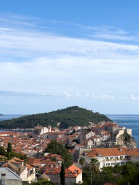 Dağlara bakan deniz kıyısında kırmızı çatıları olan eski taş evler. Dubrovnik, Hırvatistan. Yüksek kalite fotoğraf