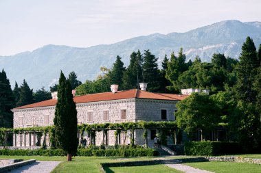 Villa Milocer, yeşil bir bahçede, yaz sisinde dağların arka planına karşı. Karadağ. Yüksek kalite fotoğraf