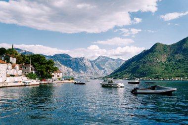 Sürat tekneleri Perast kıyısında, dağların eteğindeki antik evlerin arka planına demirlediler. Karadağ. Yüksek kalite fotoğraf