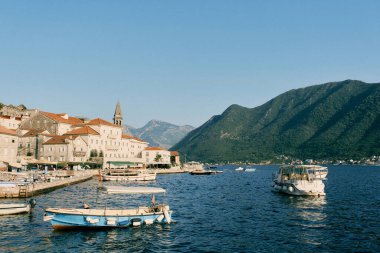 Perast kıyısında demirlemiş kadim evlere ve çan kulesine bakan gezi tekneleri var. Karadağ. Yüksek kalite fotoğraf