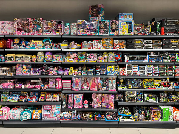 Multi-colored boxes with dolls, cars and constructors on the shelves in the supermarket. High quality photo