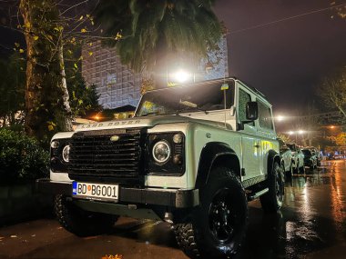 Beyaz SUV park yerinde sokak lambasının altında duruyor. Logo, Land Rover. Yüksek kalite fotoğraf