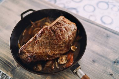 Sebzeli biftek ahşap bir masada tavada duruyor. Üst Manzara. Yüksek kalite fotoğraf
