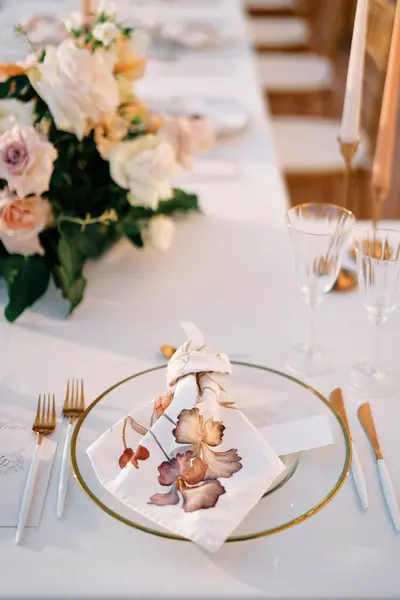 Blank invitation lies near a knotted napkin on a plate on a holiday table. High quality photo