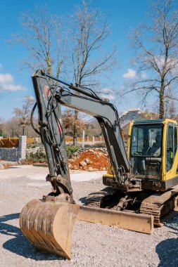 Sarı buldozer parktaki çitin yanındaki çakılların üzerinde duruyor. Yüksek kalite fotoğraf