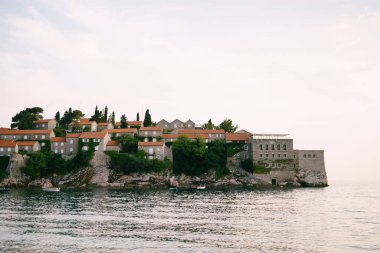 Sveti Stefan adasında kırmızı çatıları olan eski taş binalar. Karadağ. Yüksek kalite fotoğraf